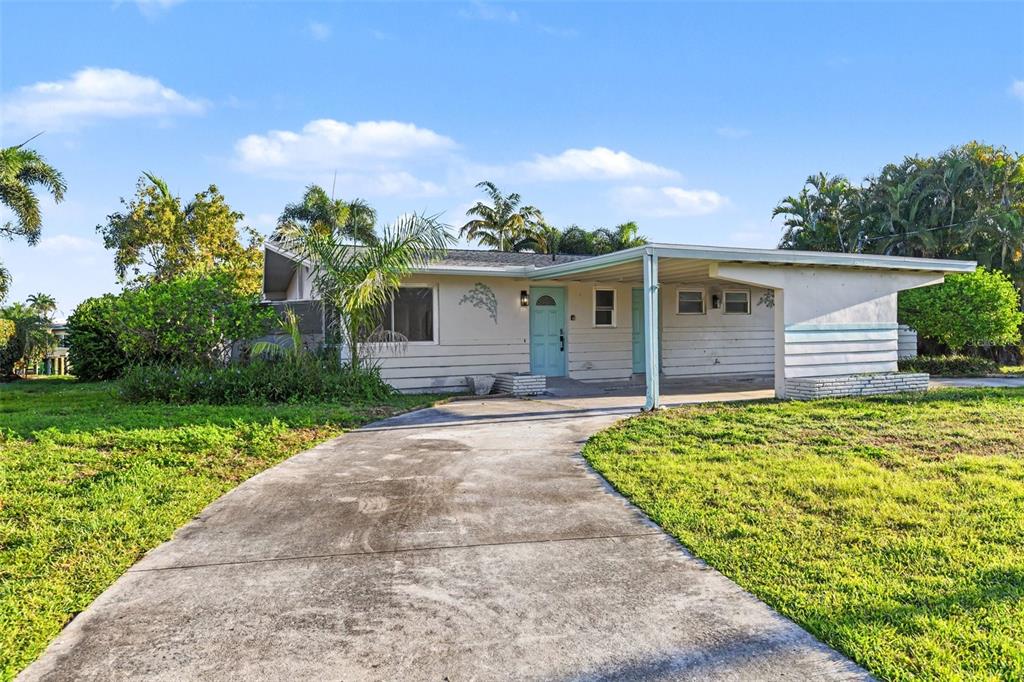 A single-story house with a light-colored exterior, a blue front door, and an attached carport — 468 GRENIER DRIVE, NORTH FORT MYERS, FL