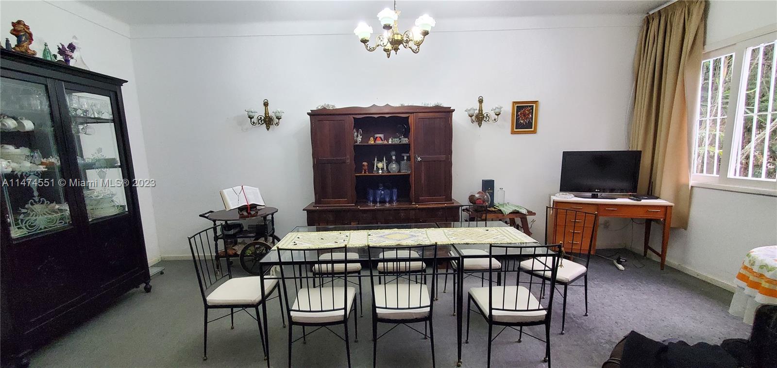 A dining room features a glass-topped table, six chairs, a wooden hutch, and a china cabinet — 311 MOSELA, FL 25675-481, FL