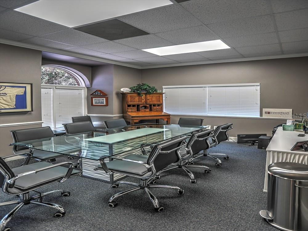 A conference room features a glass-topped table, gray carpet, and a wooden hutch — 705 DOUGLAS AVENUE, ALTAMONTE SPRINGS, FL