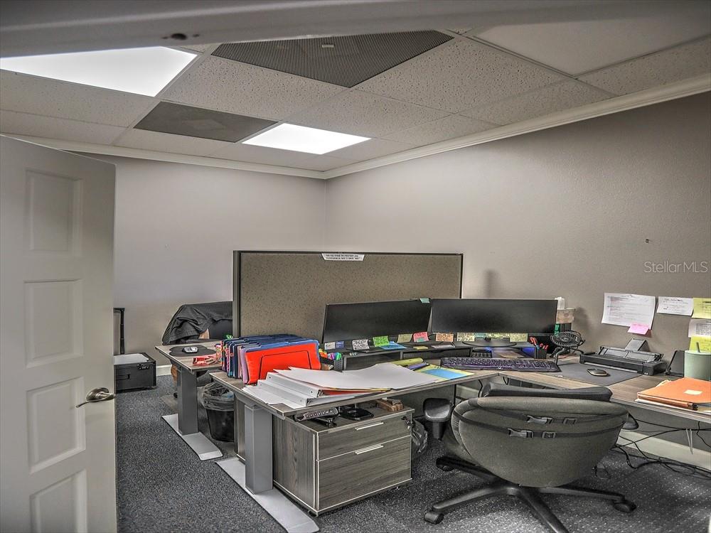 An office space features a desk with dual monitors, a gray chair, and carpeted flooring — 705 DOUGLAS AVENUE, ALTAMONTE SPRINGS, FL