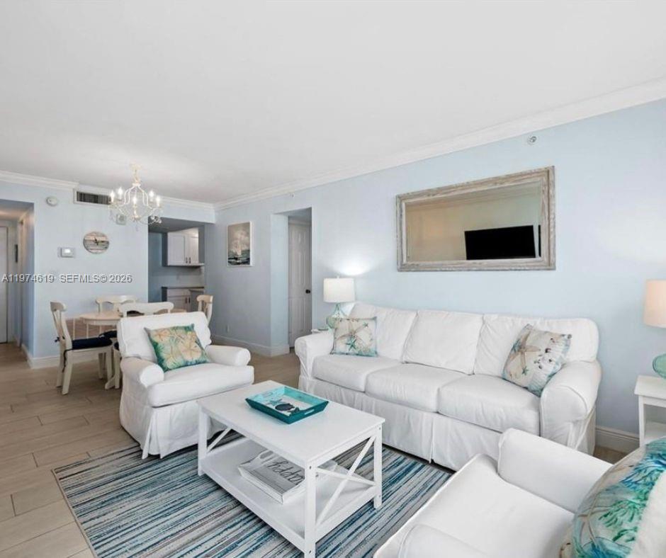 A living room with a white sofa, two armchairs, a coffee table, and light blue walls — 1505 N Riverside Dr # 505, Pompano Beach FL 33062, POMPANO BEACH, FL