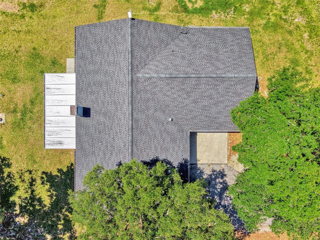 An aerial view shows a house with a gray shingled roof and a white patio — 10433 SW JERNIGAN STREET, ARCADIA, FL