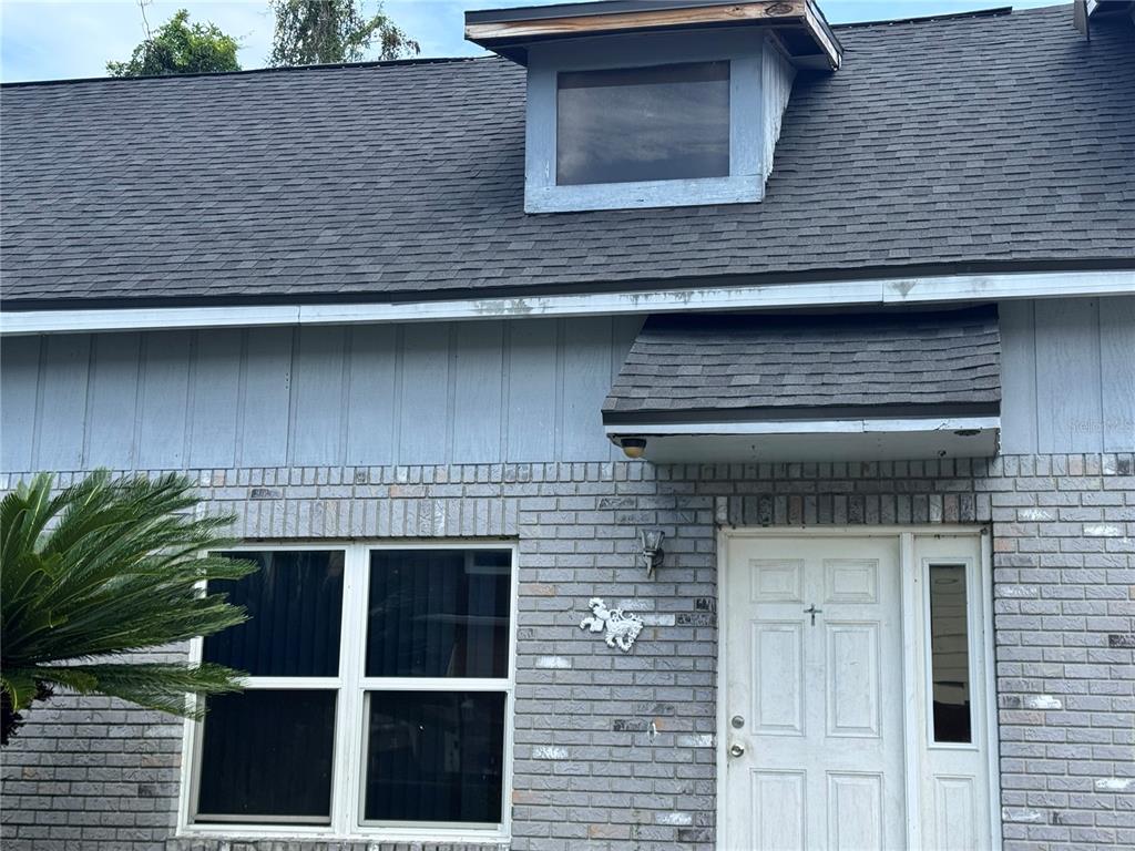 The exterior of a house features a brick facade, a dormer window, and a front door — 717 GASPARINO COURT, SEFFNER, FL