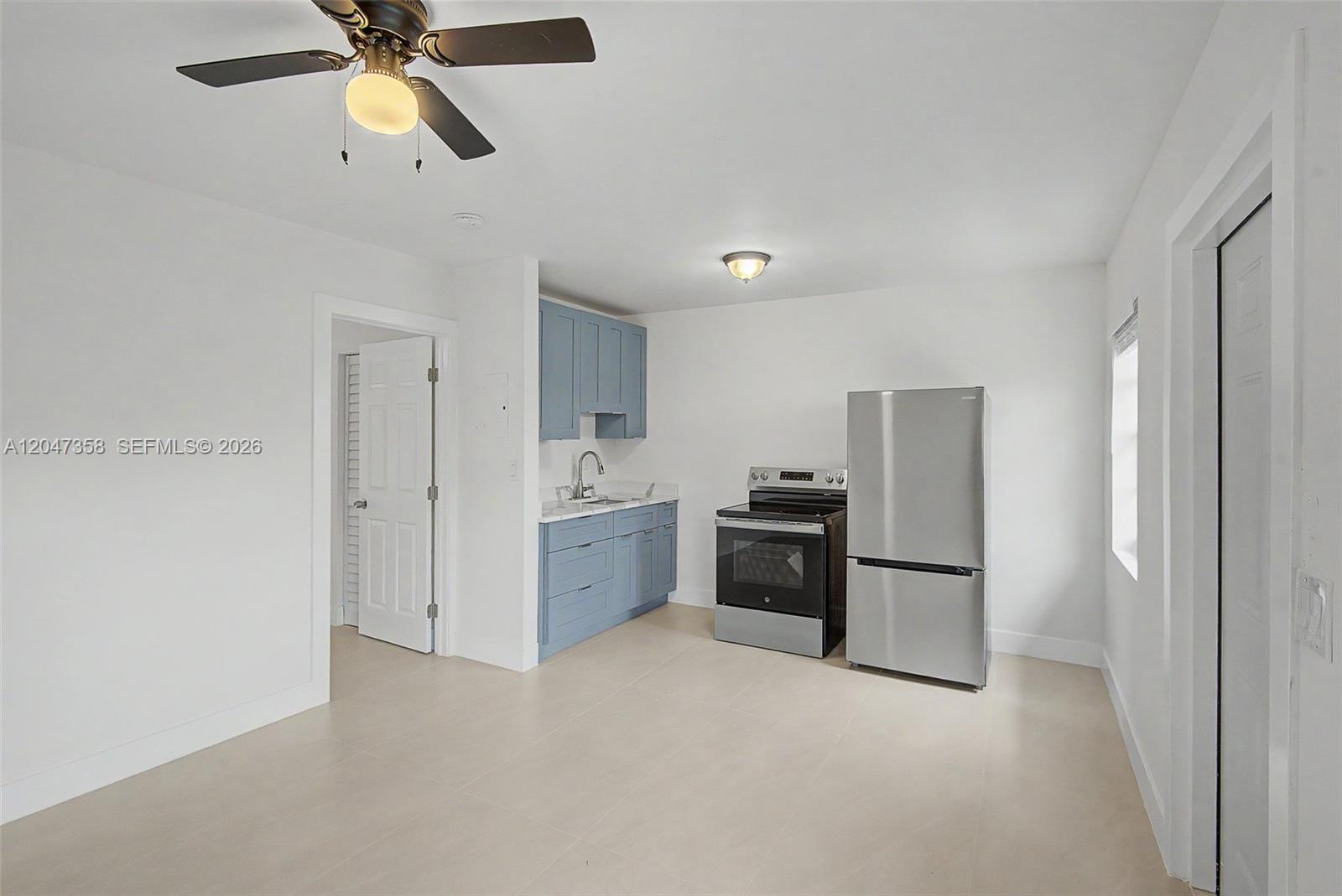 A kitchen features blue cabinets, stainless steel appliances, and light tile flooring — 1021 SW 3rd St # 6, Miami FL 33130, MIAMI, FL