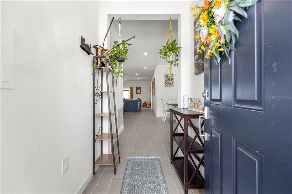 A view from an entryway into a home with light wood-look tile flooring — 3889 NE 33RD TERRACE, OCALA, FL