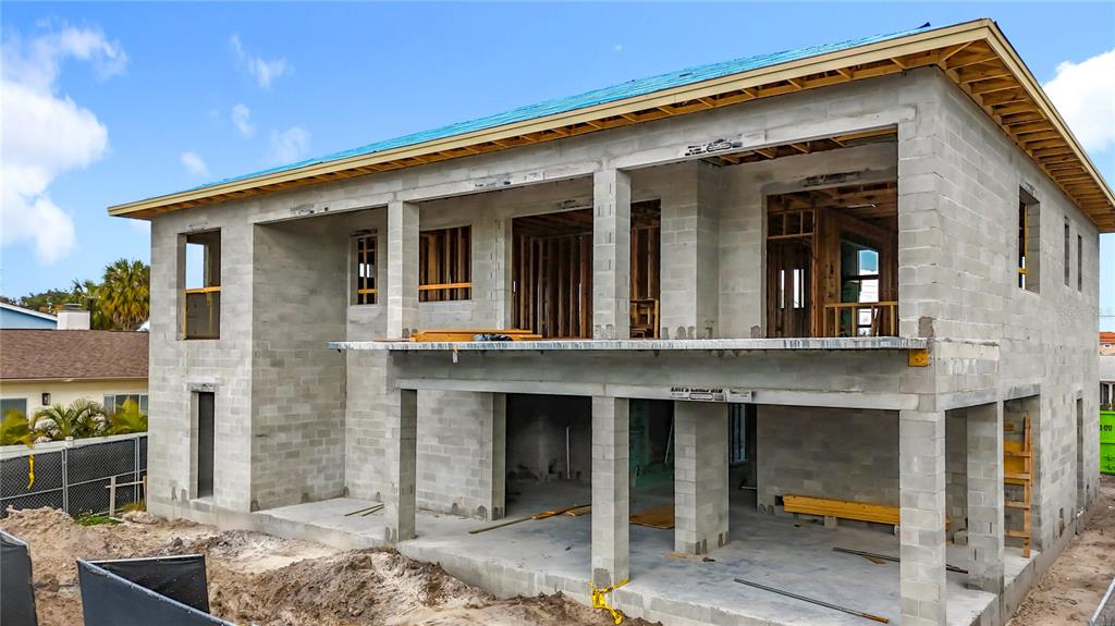 A two-story concrete block house under construction with an open-air balcony and roof framing — 4086 13TH LANE NE, ST PETERSBURG, FL