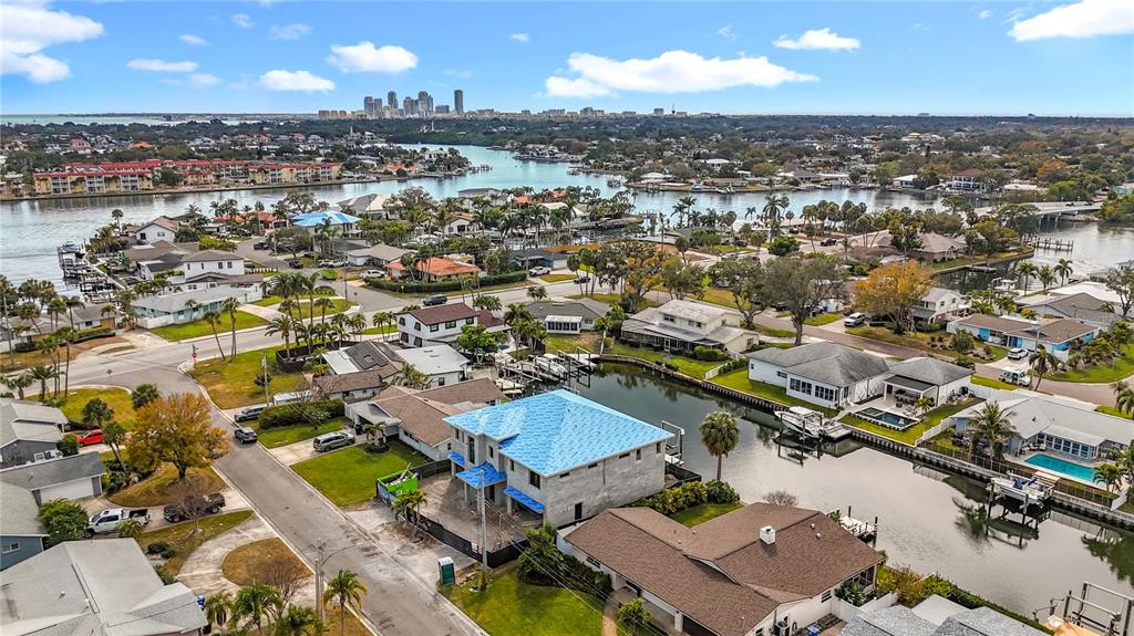 An aerial view shows a waterfront neighborhood with a house under construction featuring blue roofing — 4086 13TH LANE NE, ST PETERSBURG, FL