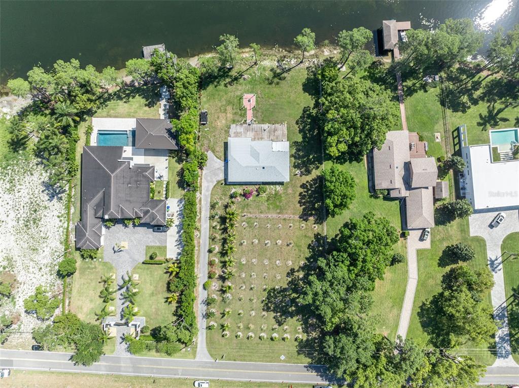 Aerial view of three waterfront residential properties with pools, docks, and landscaped yards — 7420 LAKE WILLIS DRIVE, ORLANDO, FL