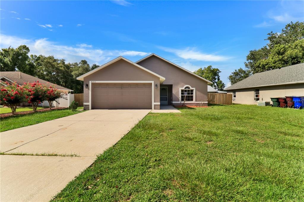 A single-story house with a tan exterior, a two-car garage, and a concrete driveway — 4305 MUTTER ROAD, ST CLOUD, FL