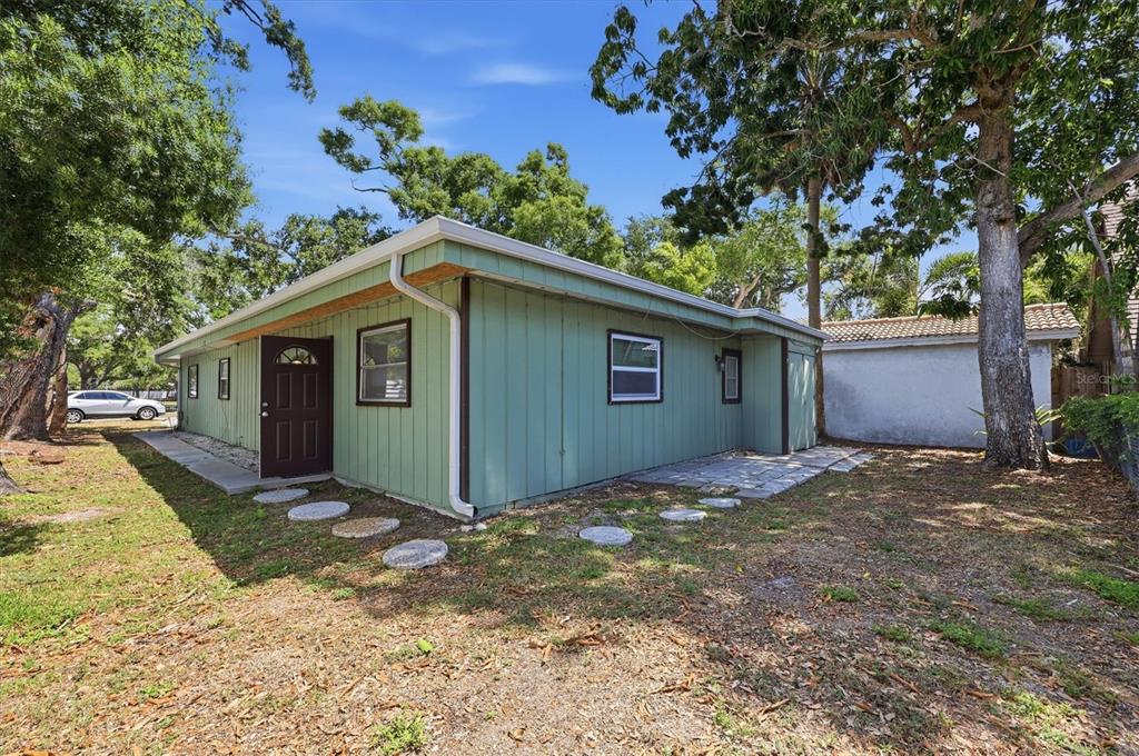A light green, single-story house with a flat roof and a dark brown front door — 1824 WEBBER STREET, SARASOTA, FL
