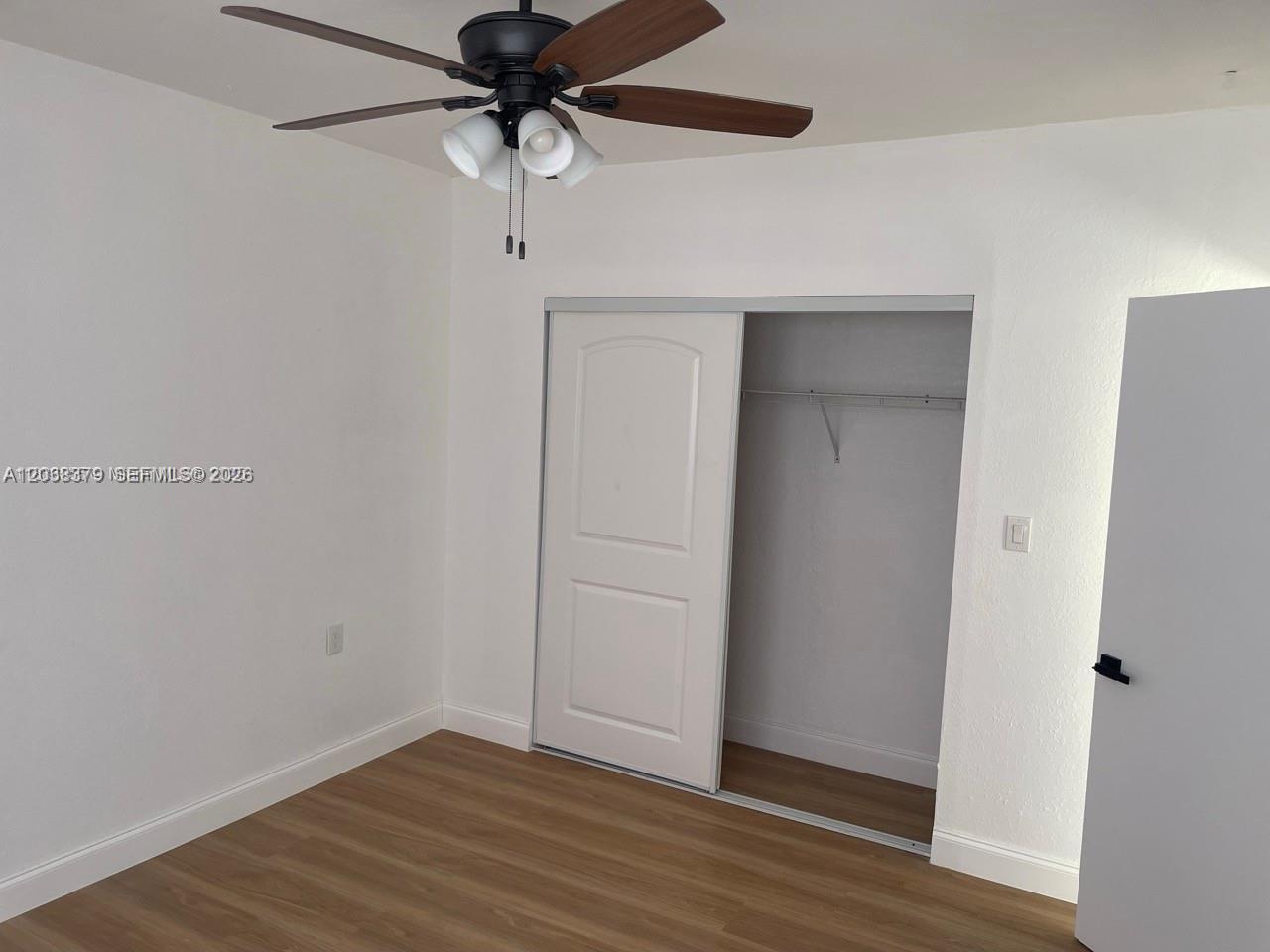 A bedroom features light wood-look flooring, a ceiling fan, and a white sliding closet door — 219 SW 21st Ave # 3, Miami FL 33135, MIAMI, FL