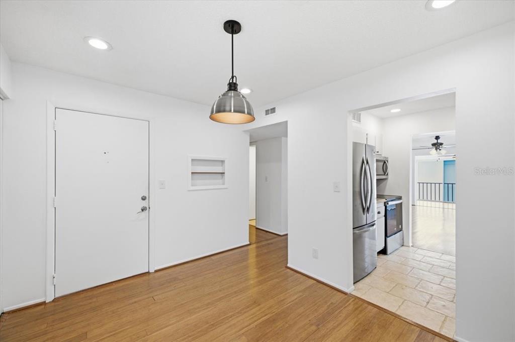 A dining area with wood flooring, a pendant light, and an adjacent kitchen — 2060 MARILYN STREET UNIT 236, CLEARWATER, FL