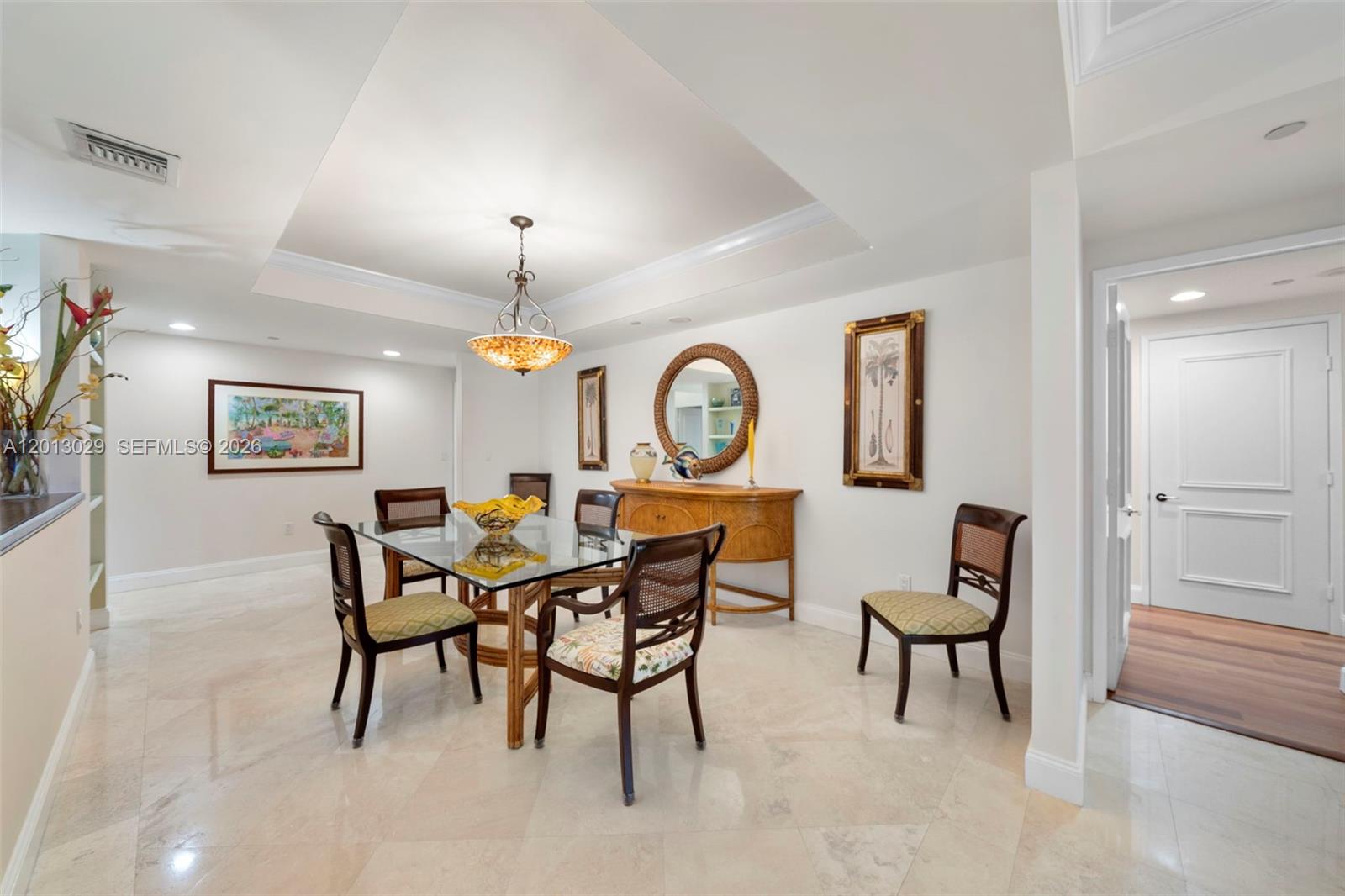 A dining room features a glass-topped table, rattan chairs, a sideboard, and a chandelier — 791 Crandon Blvd # 404, Key Biscayne FL 33149, KEY BISCAYNE, FL
