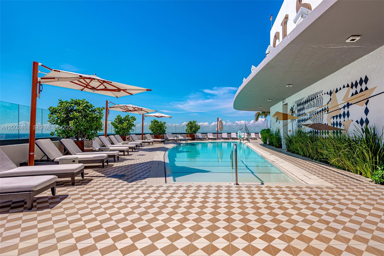 A rooftop swimming pool area features lounge chairs, umbrellas, and a patterned tiled deck — 801 S Miami Ave # 4608, Miami FL 33130, MIAMI, FL