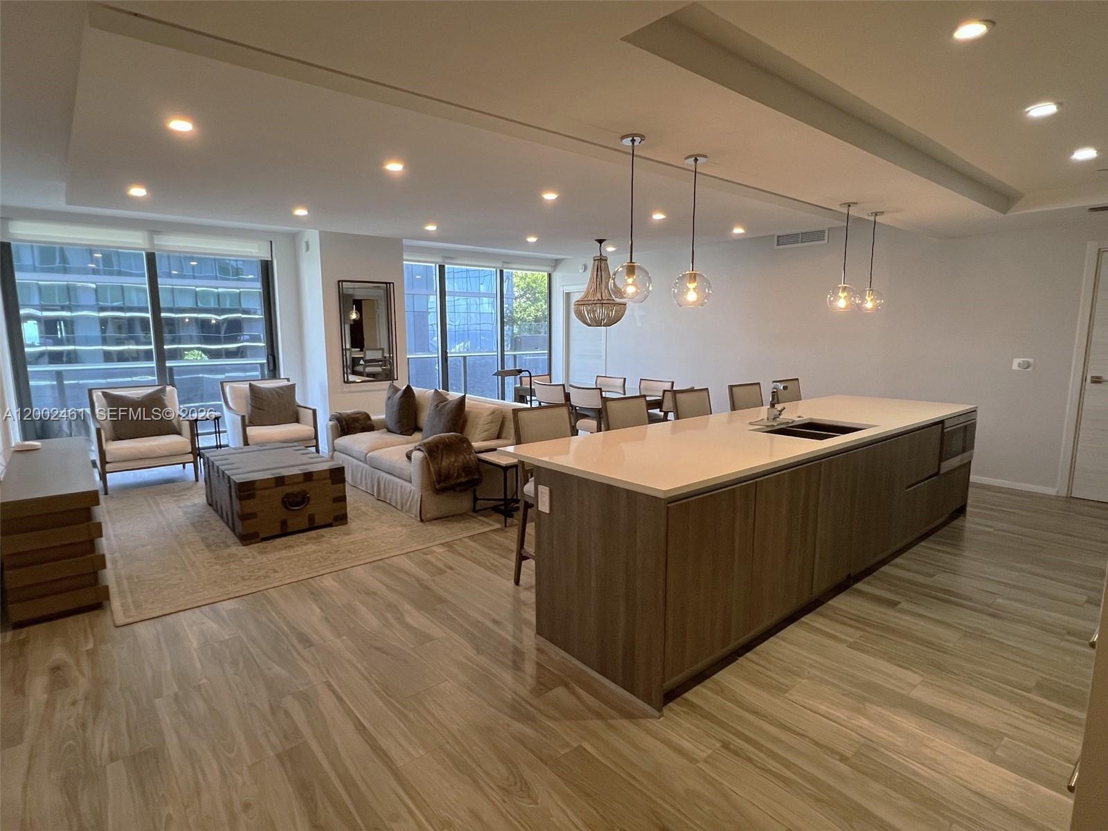 A modern open-concept living area features a kitchen island, dining table, and lounge seating — 801 S Miami Ave # 4608, Miami FL 33130, MIAMI, FL