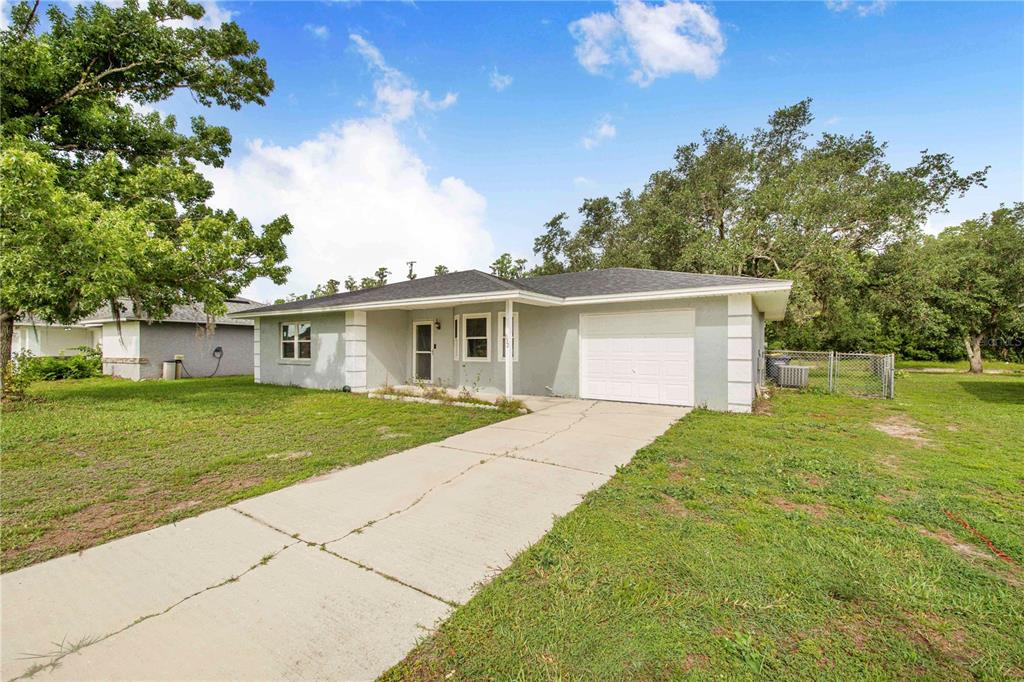 A single-story house with a light gray exterior, white trim, and a concrete driveway — 632 REINDEER DRIVE, POINCIANA, FL
