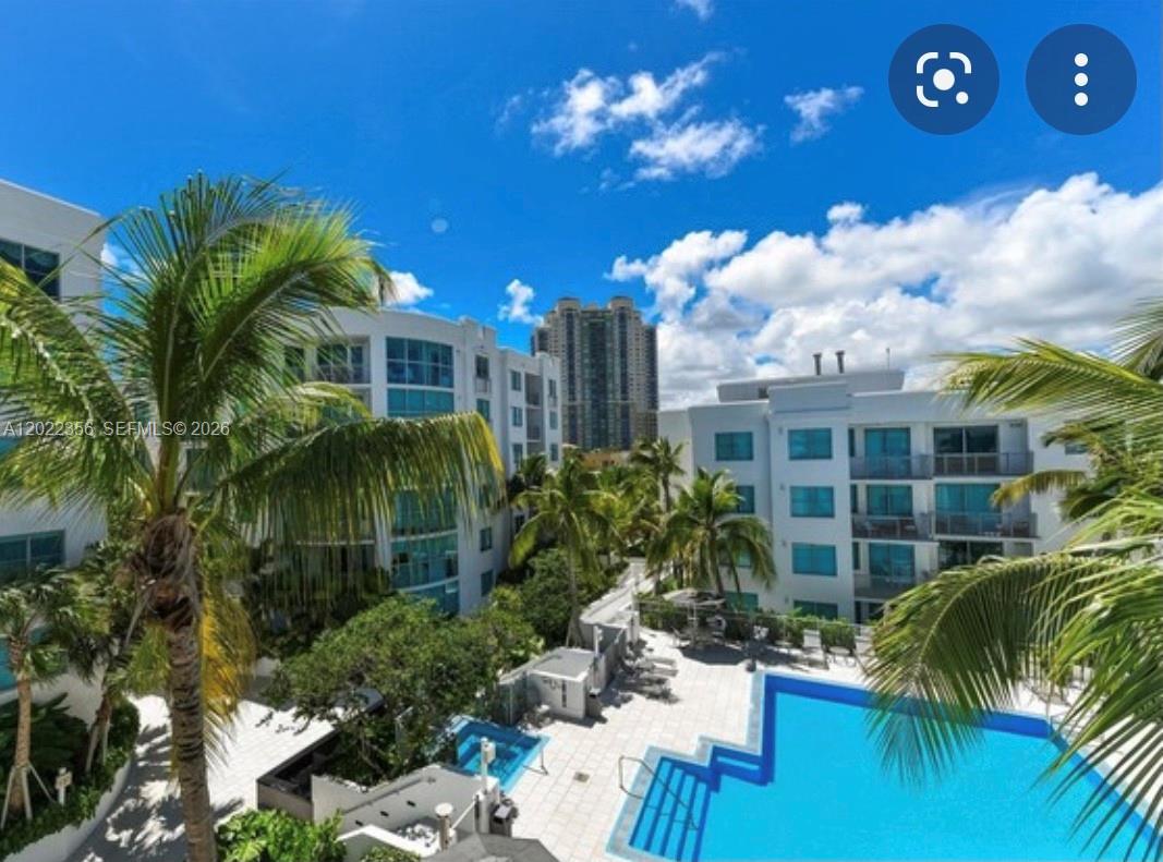 An elevated view of an outdoor swimming pool surrounded by multi-story white apartment buildings — 110 Washington Ave # 1614, Miami Beach FL 33139, MIAMI BEACH, FL