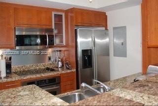 A kitchen features wood cabinets, granite countertops, stainless steel appliances, and a double sink — 110 Washington Ave # 1614, Miami Beach FL 33139, MIAMI BEACH, FL