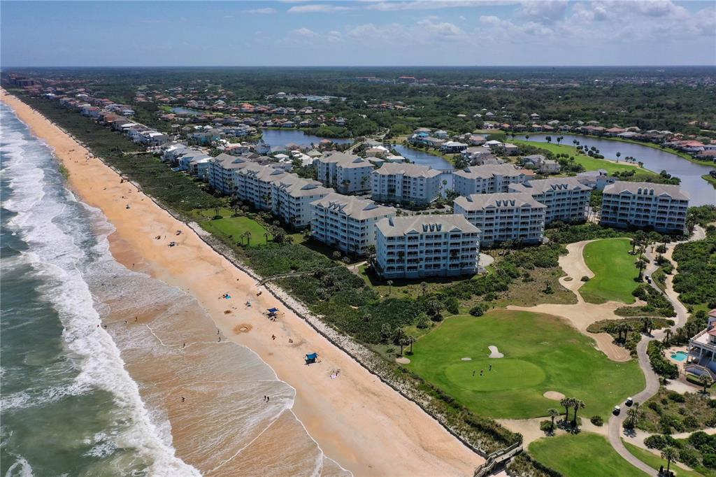 An aerial view shows beachfront condominiums situated next to a golf course and the ocean — 1000 CINNAMON BEACH WAY UNIT 942, PALM COAST, FL