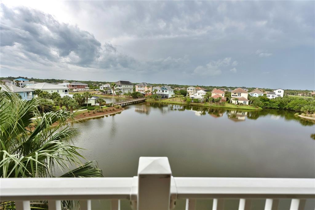 A view from a balcony overlooking a lake surrounded by houses and palm trees — 1000 CINNAMON BEACH WAY UNIT 942, PALM COAST, FL