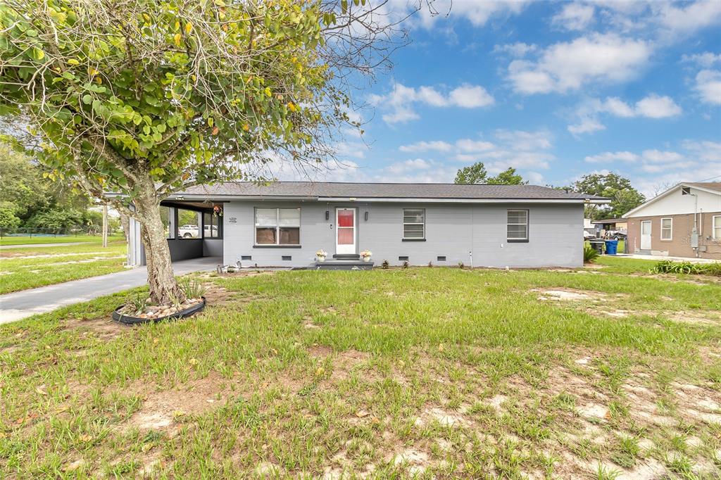 A single-story gray house with a carport and a large tree in the front yard — 320 S SEMINOLE AVENUE, LAKE ALFRED, FL