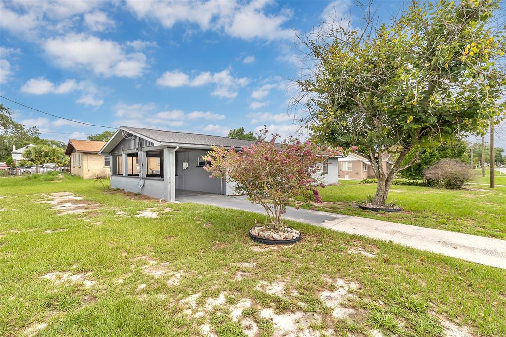 A gray single-story house with a carport and a large tree in the front yard — 320 S SEMINOLE AVENUE, LAKE ALFRED, FL