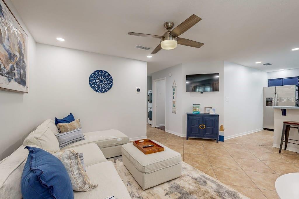 A living room features a white sectional sofa, a matching ottoman, and a blue cabinet — 111 GULF WINDS COURT UNIT 111, DESTIN, FL