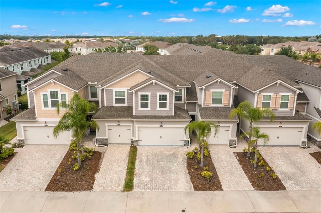 An aerial view of a multi-unit townhouse complex with attached garages and paved driveways — 5018 SUNNYSIDE LANE, BRADENTON, FL