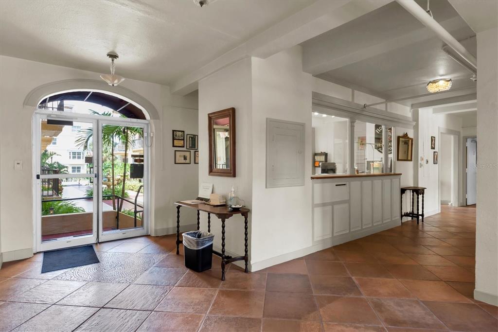 A lobby features tile floors, a reception desk, and glass doors opening to a courtyard — 130 4TH AVENUE N UNIT 201, ST PETERSBURG, FL