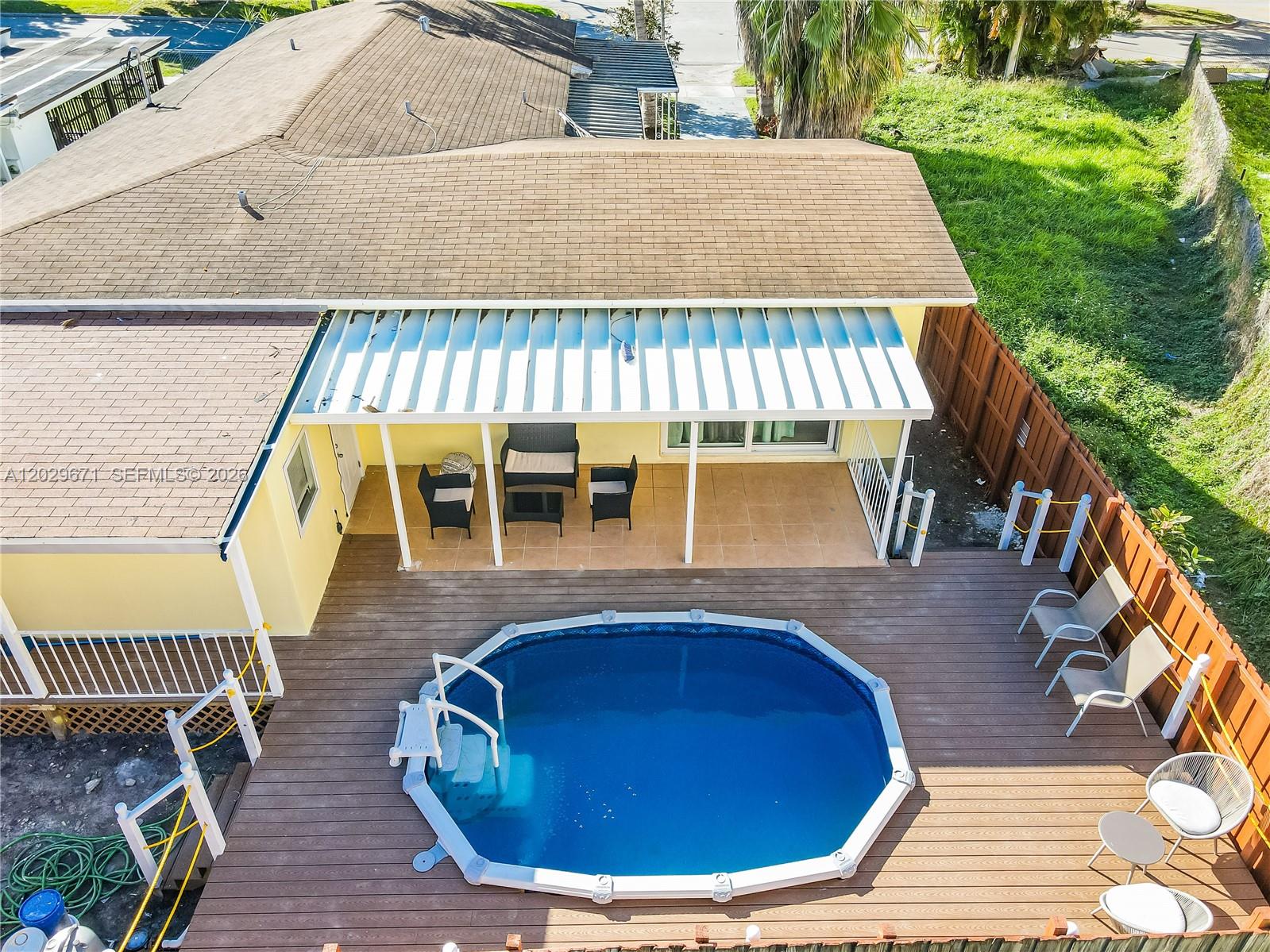 An aerial view shows a backyard with a pool, wooden deck, and covered patio area — 1021 NW 23rd Ave # 1023, Miami FL 33125, MIAMI, FL