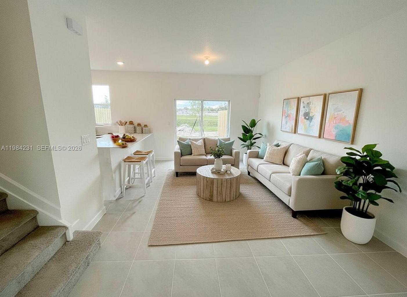 A living room features a beige sofa, a round wooden coffee table, and a kitchen island — 12354 NW 23rd Ct, Miami FL 33167, MIAMI, FL