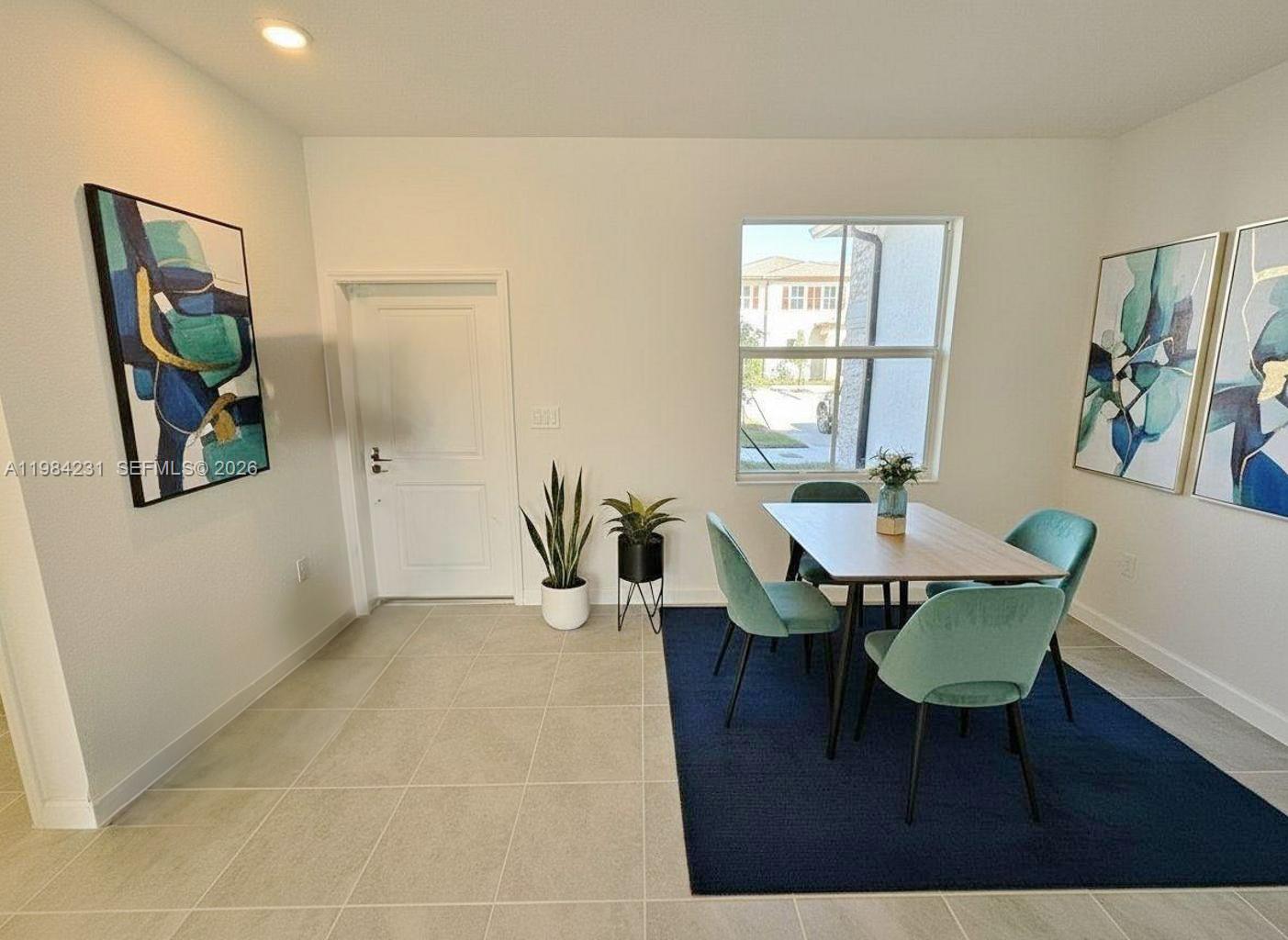 A dining area features a table with four chairs, a blue rug, and wall art — 12354 NW 23rd Ct, Miami FL 33167, MIAMI, FL