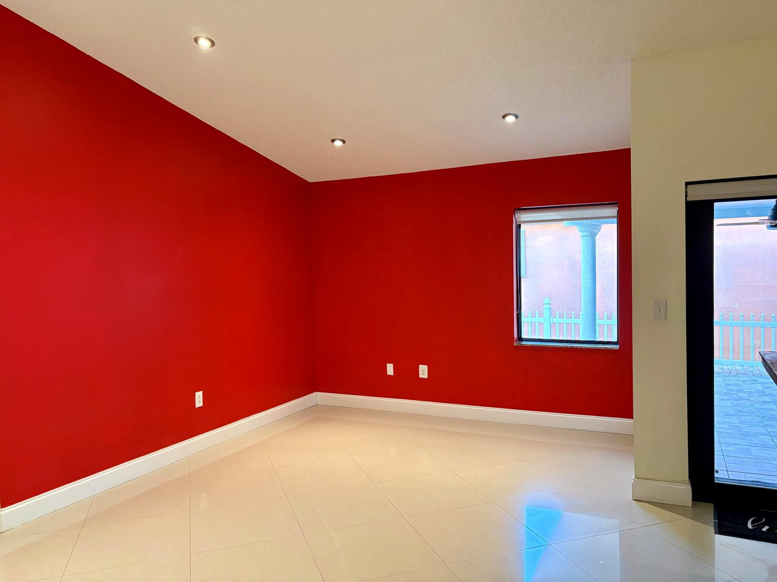 An empty room with bright red walls, recessed lighting, and light-colored tile flooring — 14776 SW 138th Terrace, Miami FL 33196, MIAMI, FL