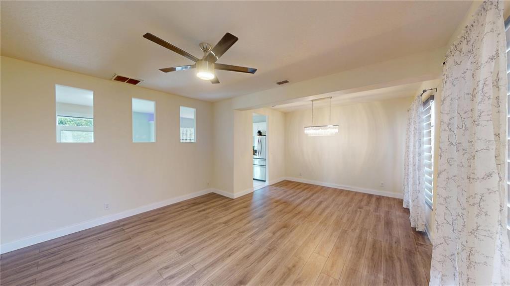 An open living and dining area with wood-look flooring, a ceiling fan, and recessed windows — 3044 CAMINO REAL DRIVE S, KISSIMMEE, FL