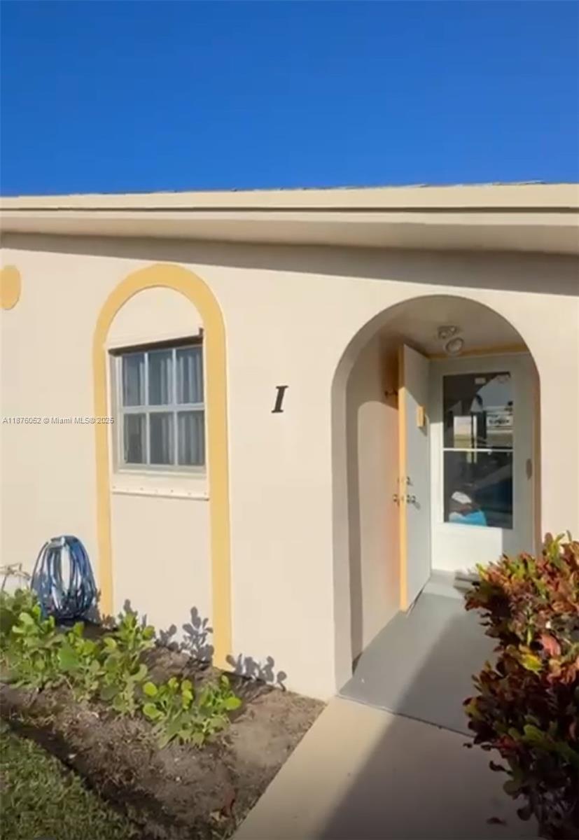 The exterior of a beige building features an arched entryway and a single window — 2622 E Emory Drive # I, West Palm Beach FL 33415, WEST PALM BEACH, FL