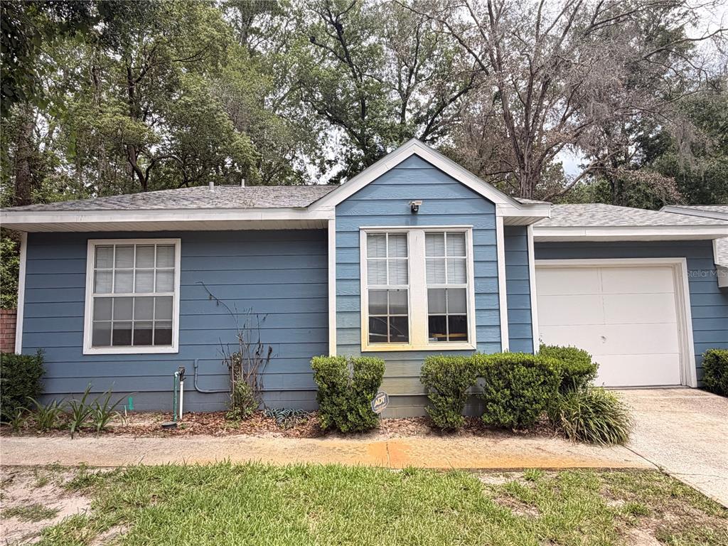 A blue, single-story house with a white garage door and two front windows — 439 NW 50TH BOULEVARD, GAINESVILLE, FL