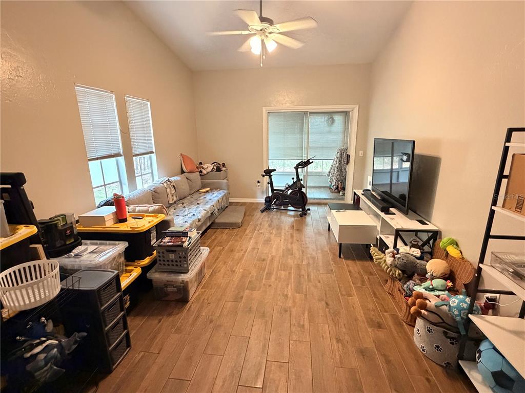 A view from a hallway looking into a kitchen with wood-look flooring and white doors — 439 NW 50TH BOULEVARD, GAINESVILLE, FL