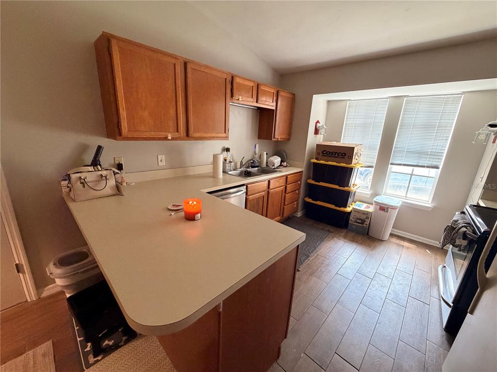 A kitchen features wood cabinets, a laminate countertop, and a windowed dining area — 439 NW 50TH BOULEVARD, GAINESVILLE, FL