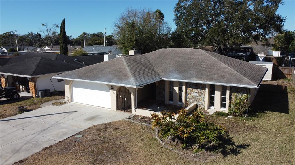 An aerial view of a single-story house with a stone facade and a two-car garage — 8533 VIVA VIA DRIVE, HUDSON, FL