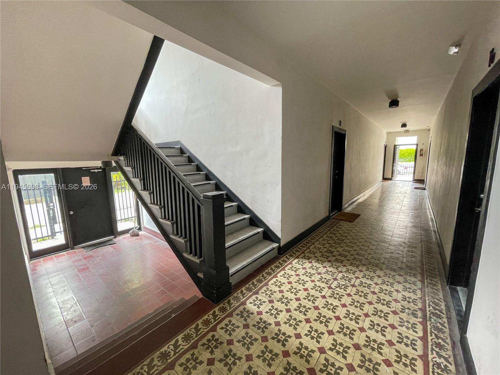 An indoor hallway features patterned tile flooring, a dark wooden staircase, and multiple doorways — 36 NE 65th St, Miami FL 33138, MIAMI, FL