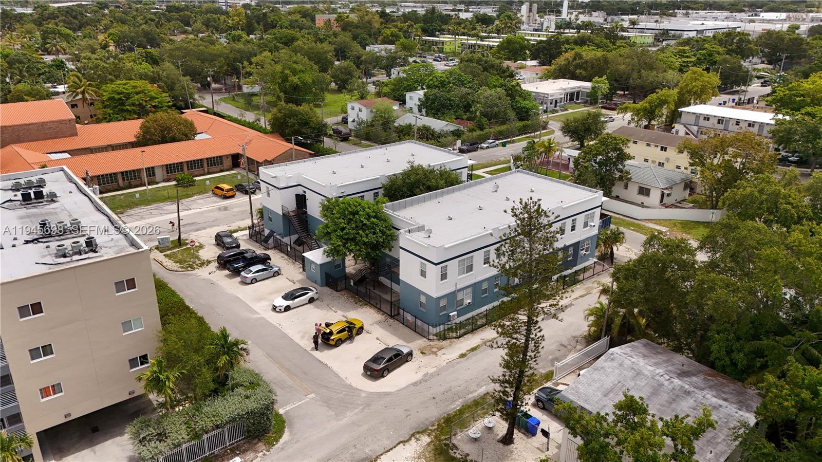 An aerial view shows two multi-story apartment buildings with parking lots and surrounding trees — 36 NE 65th St, Miami FL 33138, MIAMI, FL