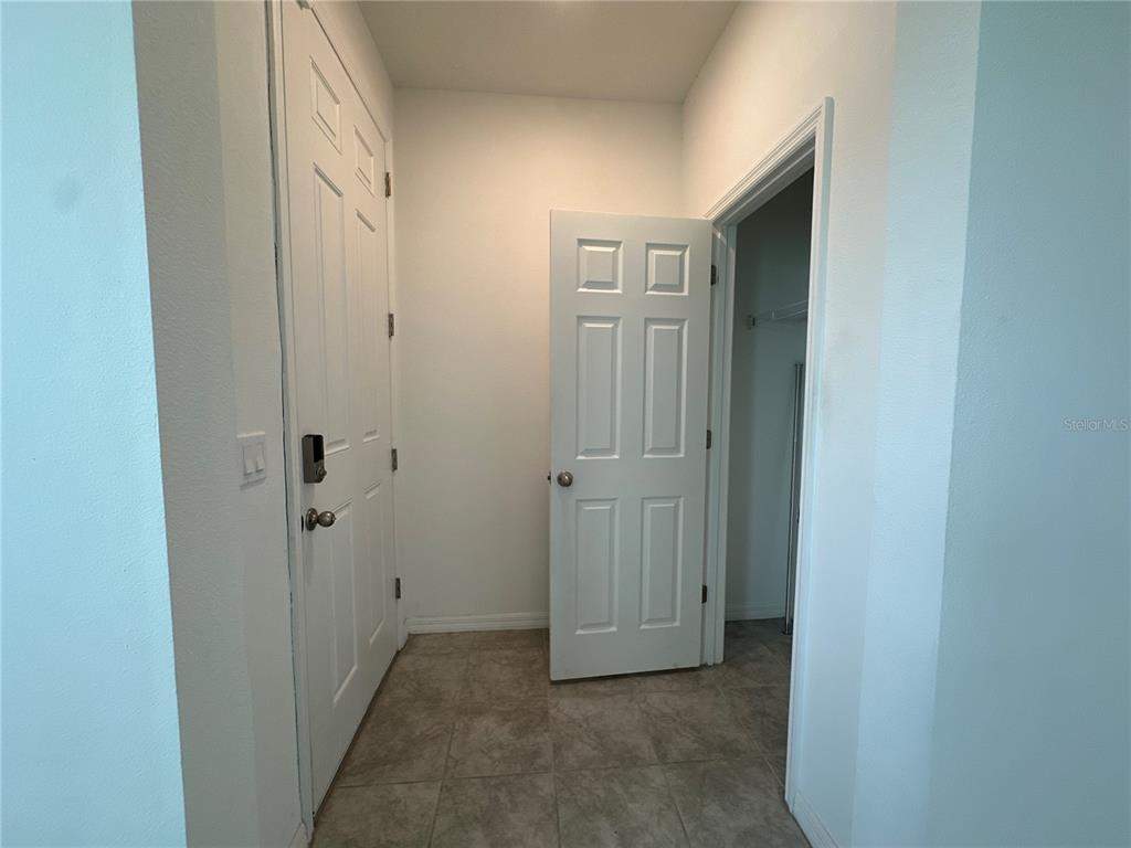 An entryway features a white front door, a closet door, and light-colored tile flooring — 4724 HOMESTEAD TRAIL, ST CLOUD, FL
