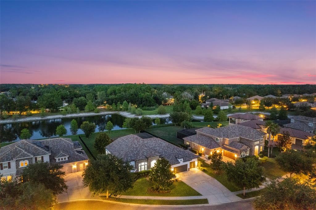 An aerial view of suburban houses with tile roofs and driveways near a small lake — 17425 VARONA PLACE, LUTZ, FL