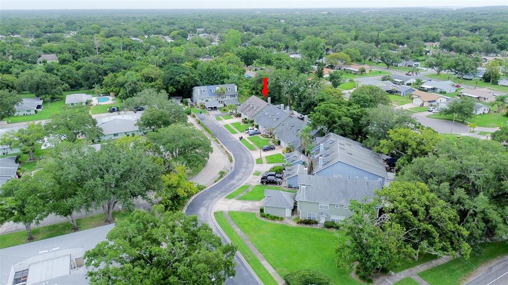 An aerial view shows a residential neighborhood with townhomes, green lawns, and mature trees — 2740 HAMBLE VILLAGE LANE, PALM HARBOR, FL