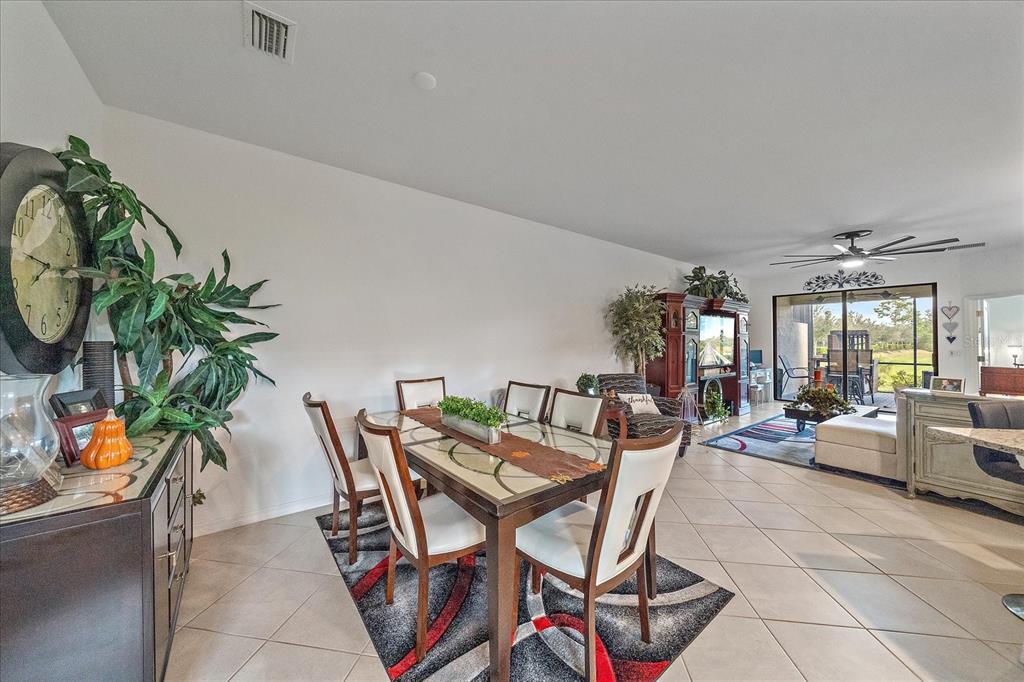 A dining area with a glass-topped table sits adjacent to a living room with tile — 2016 BONITO WAY, PORT CHARLOTTE, FL