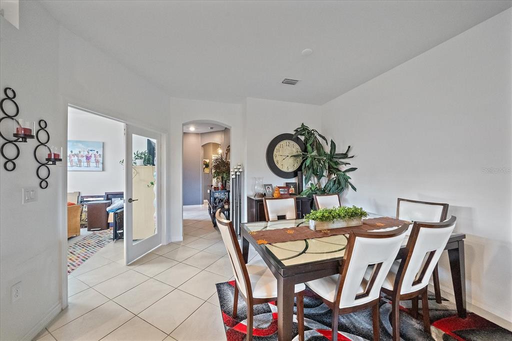 A dining room features a glass-topped table, white chairs, and a patterned area rug — 2016 BONITO WAY, PORT CHARLOTTE, FL
