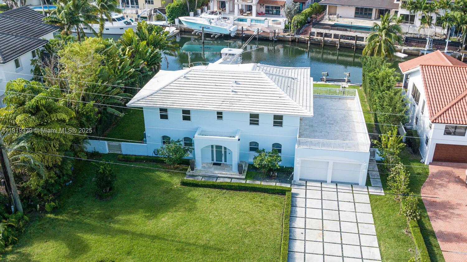 An aerial view shows a two-story light blue house with a white roof and a driveway — 1130 Lugo Ave, Coral Gables FL 33156, CORAL GABLES, FL