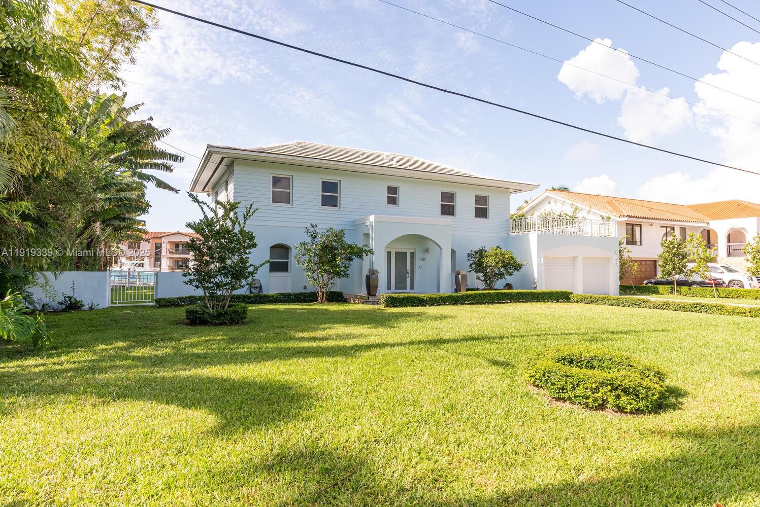 A two-story light blue house with a large front lawn and a white fence — 1130 Lugo Ave, Coral Gables FL 33156, CORAL GABLES, FL