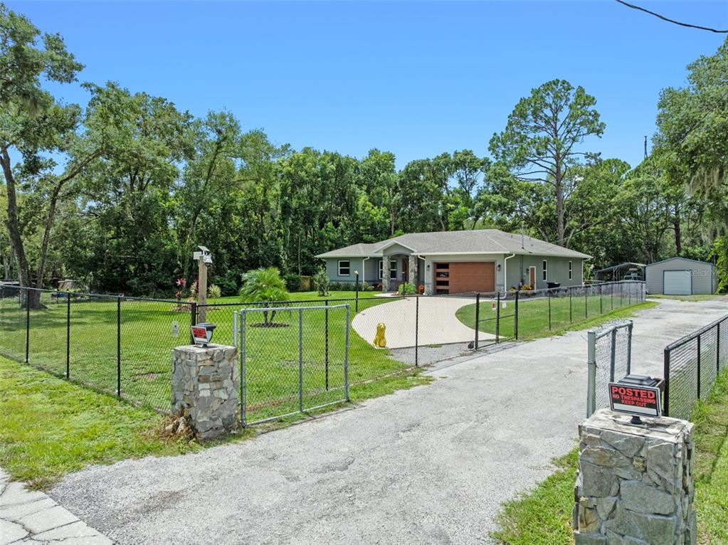 A single-story house with a garage sits behind a fenced yard and a gated driveway — 308 CHURCH STREET, LAKE HELEN, FL