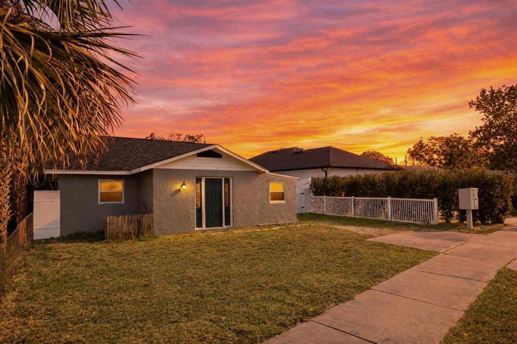 A gray single-story house with a dark roof stands under a vibrant sunset sky — 5419 OLD CHENEY HIGHWAY, ORLANDO, FL